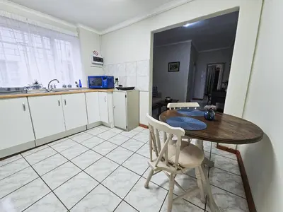 a kitchen with a table and chairs in a room at Dutch on Tecoma, Wonderboom, Pretoria in Pretoria