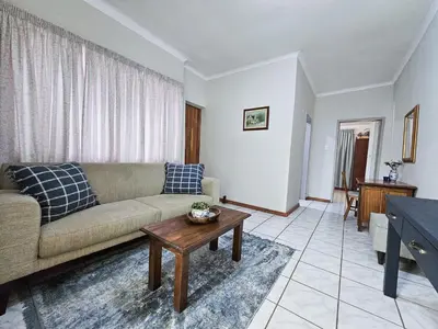 a living room with a couch and a table at Dutch on Tecoma, Wonderboom, Pretoria in Pretoria