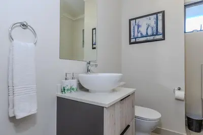 a white bathroom with a sink and a toilet at The Resting Nest Delight in Midrand