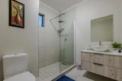 a bathroom with a shower and a toilet and a sink at The Resting Nest Delight in Midrand