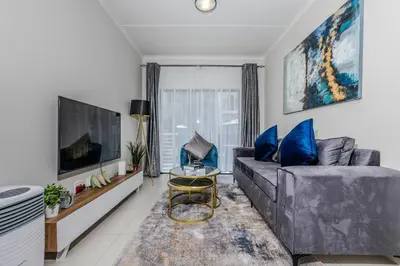 a living room with a couch and a tv at The Resting Nest Delight in Midrand