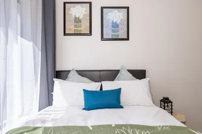 a bedroom with a bed with blue and white pillows at The Resting Nest Delight in Midrand