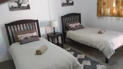 two beds sitting next to each other in a room at Paperbark Self Catering Units in Doornfontein