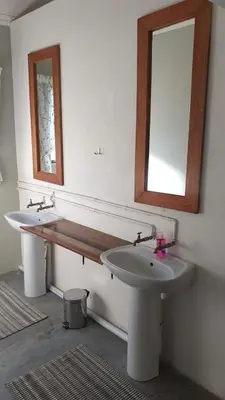 a bathroom with two sinks and a mirror at Paperbark Self Catering Units in Doornfontein