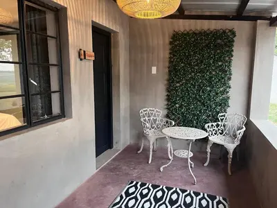 a group of chairs and a table on a patio at Frere Guesthouse in Ermelo