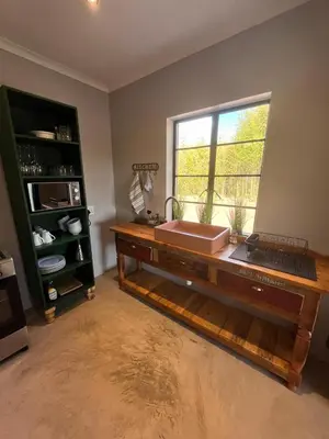 a bathroom with a wooden counter with a window at Frere Guesthouse in Ermelo
