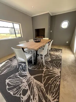 a dining room with a wooden table and chairs at Frere Guesthouse in Ermelo