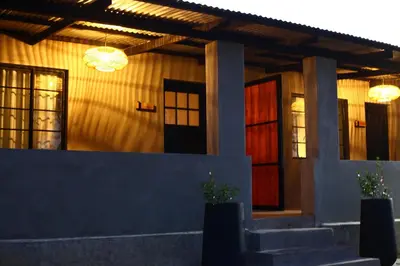 a house with a red door and two windows at Frere Guesthouse in Ermelo