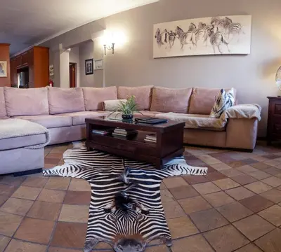 a living room with a couch and a zebra rug at Tuareg Guest House in Midrand