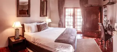 a bedroom with a large bed and a window at Tuareg Guest House in Midrand