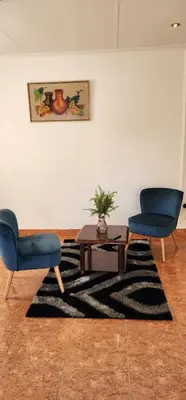 a living room with two chairs and a table at Khayelihle Guest house in Benoni