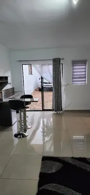 a living room with a table and two chairs at Khayelihle Guest house in Benoni