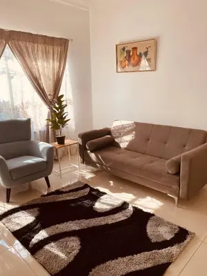 a living room with a couch and a chair at Khayelihle Guest house in Benoni