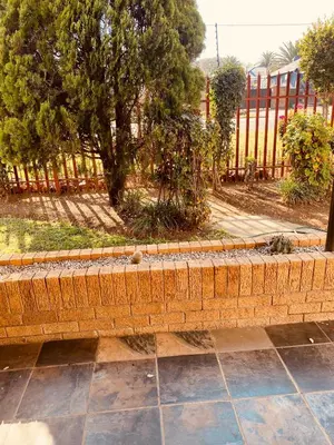 a brick bench in front of a fence at Khayelihle Guest house in Benoni