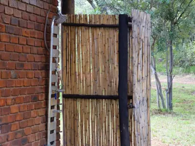 a wooden gate in front of a brick wall at Masungulo Lodge in Modimolle