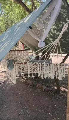 a white hammock hanging off the side of a house at Elephant Memories Glamping Safari Tents and more in Marloth Park