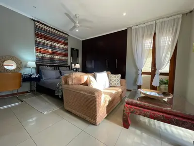 a living room with a couch and a bed at Jade Mountain Cottage \u7389\u5c71\u5c0f\u5c4b in White River