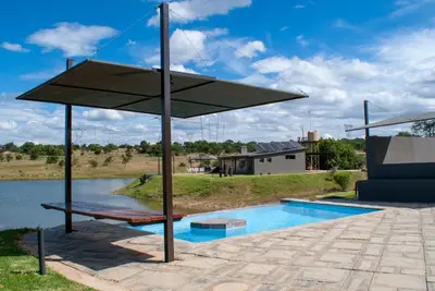 a large umbrella next to a swimming pool at Casa de la Presa 3 in Polokwane