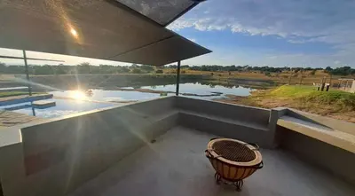 a room with a tub with a view of a river at Casa de la Presa 3 in Polokwane