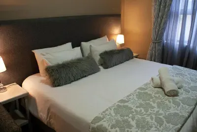 a bedroom with a bed with two pillows on it at Casa de la Presa 3 in Polokwane