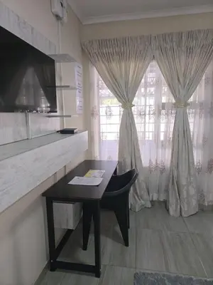 a room with a desk and a window with curtains at Peshline Guest House Unit 2 in Ermelo