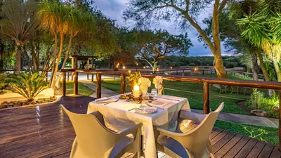 a table and chairs on a wooden deck at Phelwana Game Lodge in Hoedspruit