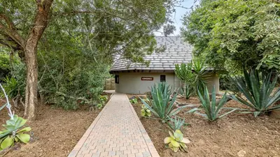 a brick walkway leading to a small building at Phelwana Game Lodge in Hoedspruit