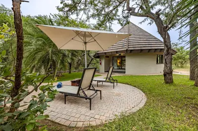 two chairs and an umbrella on a patio at Phelwana Game Lodge in Hoedspruit
