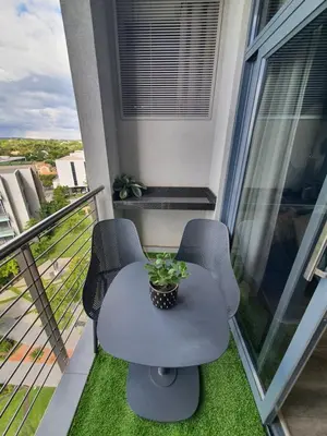 a table and two chairs on a balcony at GreenLeaf Stays - Menlyn Maine Apartments in Pretoria