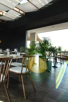 a restaurant with tables and chairs and potted plants at GreenLeaf Stays - Menlyn Maine Apartments in Pretoria