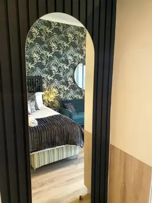 a bedroom with a bed and a mirror at GreenLeaf Stays - Menlyn Maine Apartments in Pretoria
