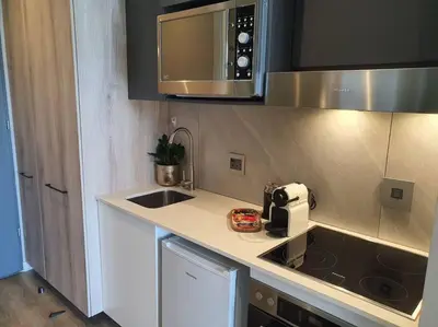 a kitchen with a sink and a stove and a microwave at GreenLeaf Stays - Menlyn Maine Apartments in Pretoria