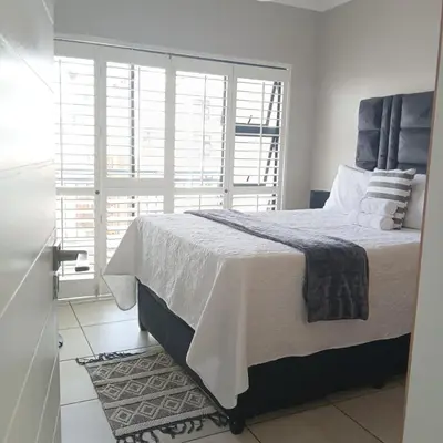 a bedroom with a bed and a large window at The Blyde 2 bedrooms Luxe Marvelous Apartment in Pretoria