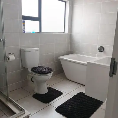 a bathroom with a toilet and a tub and a window at The Blyde 2 bedrooms Luxe Marvelous Apartment in Pretoria
