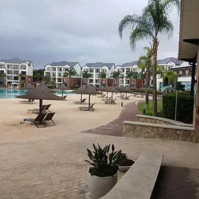 a resort with tables and umbrellas and a pool at The Blyde 2 bedrooms Luxe Marvelous Apartment in Pretoria