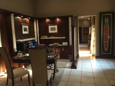 a living room with a table and chairs and a hallway at Witwater Guest House & Spa in Kempton Park