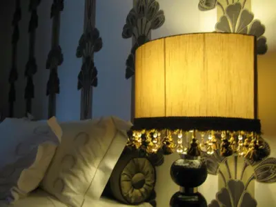 a lamp sitting next to a bed with a clock at Witwater Guest House & Spa in Kempton Park