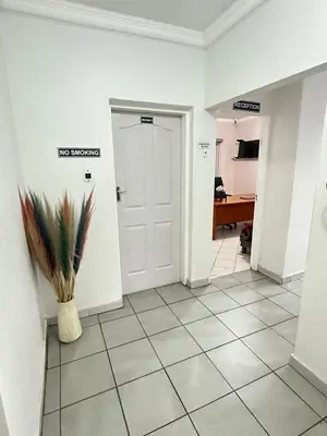 a hallway with a door and a tile floor at Creekside Guest House Middelburg in Middelburg