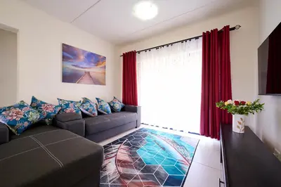 a living room with a couch and a window at Cozy Escape: 2 BR Apt. Sleeps 4 in Midrand