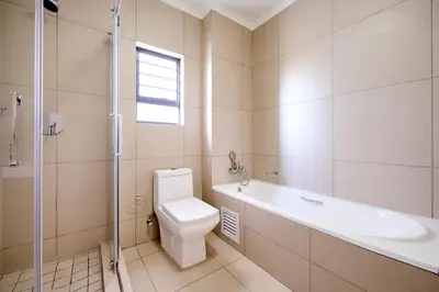 a bathroom with a toilet and a tub and a sink at Cozy Escape: 2 BR Apt. Sleeps 4 in Midrand
