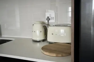 a kitchen counter with a toaster and a toaster and a cutting board at Urban Oasis Retreat in Midrand