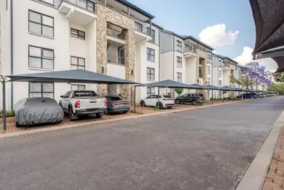 a street with cars parked in front of a building at Urban Oasis Retreat in Midrand