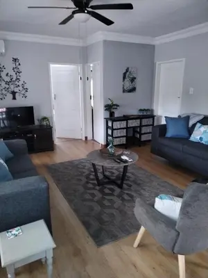 a living room with a couch and a table at Jan's Cottage in Centurion