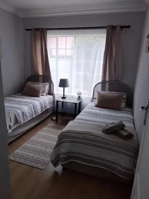 a bedroom with two beds and a window at Jan's Cottage in Centurion