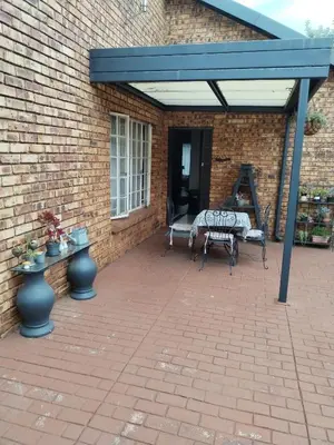 a covered patio with a bench and a table at Jan's Cottage in Centurion