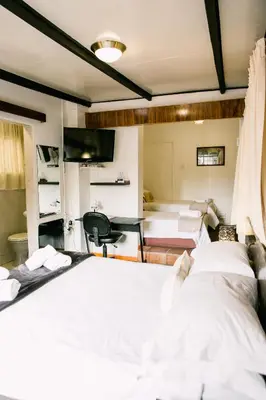 a hotel room with two beds and a tv at Pennylane Guest House in Ermelo