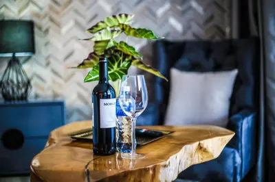 a bottle of wine and glasses on a wooden table at Villameyer Lodge in Pretoria