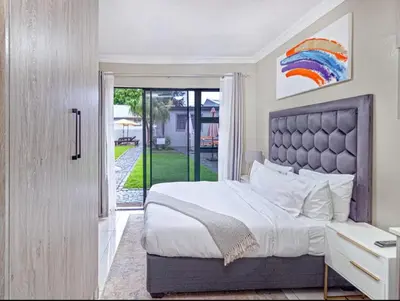 a bedroom with a bed and a door to a yard at Villameyer Lodge in Pretoria