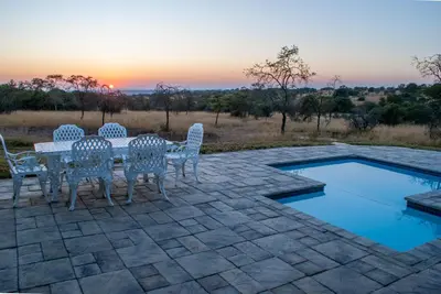 a patio with a table and chairs next to a pool at Casa de la Presa 2 in Polokwane