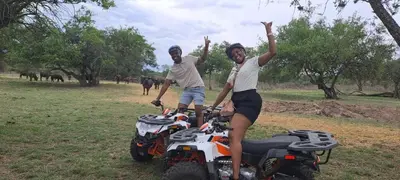 two men are standing next to atvs in a field at Casa de la Presa 2 in Polokwane